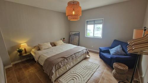a bedroom with a bed and a blue couch at Meu Sonho Cascais - Praia in Alcabideche