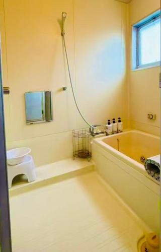 a bathroom with a tub and a toilet and a sink at Biwa Asahi 家族友人大人数ok BBQok in Takashima