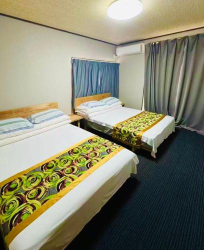 a hotel room with two beds in a room at Biwa Asahi 家族友人大人数ok BBQok in Takashima