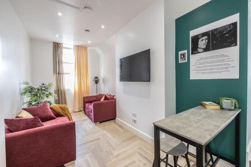 a living room with two red chairs and a table at The Pocklington Aparthotel - Luxury 1 & 2 Bed Serviced Apartments, City Centre, Perfect For Families, Contractors and Businesses in Leicester