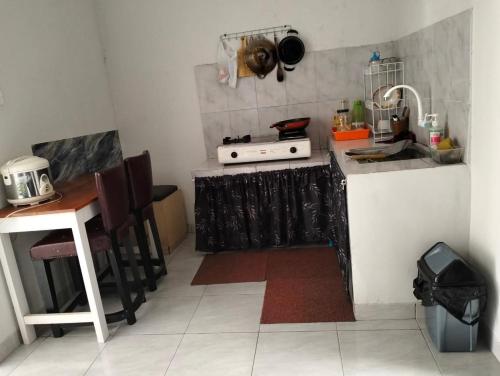 a small kitchen with a stove and a table at Herald homestay wonosobo in Wonosobo