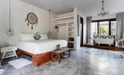 a bedroom with a large bed and a bath tub at Sanara Tulum in Tulum