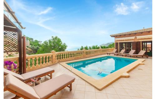 a swimming pool on a deck with chairs and a house at Torre De Heretat in Canyamel