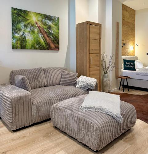 a living room with a couch and a ottoman at wohlBfinden appartementhaus in Braunlage