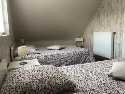 une chambre avec deux lits et une lampe sur une table dans l'établissement La Grange, à Plélan-le-Petit
