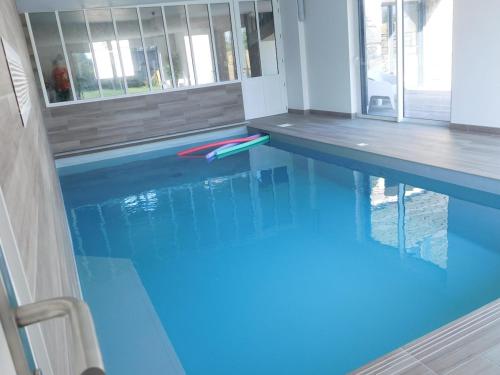 une piscine avec de l'eau bleue dans une maison dans l'établissement La Grange, à Plélan-le-Petit