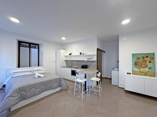 a bedroom with a bed and a desk and a table at BBkey Corte San Daniele in San Daniele del Friuli