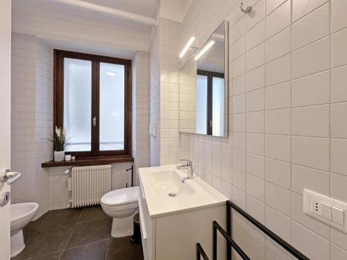 a white bathroom with a sink and a toilet at BBkey Corte San Daniele in San Daniele del Friuli