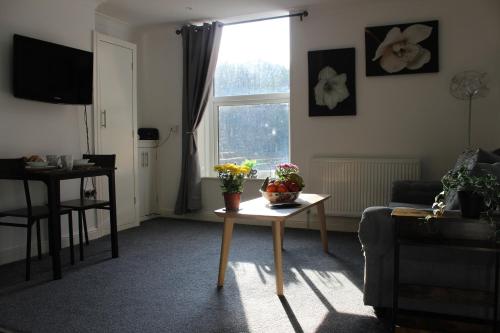 a living room with a table with flowers on it at Oliver Wests Beautiful 1 Bedroom Retreat in Scarborough
