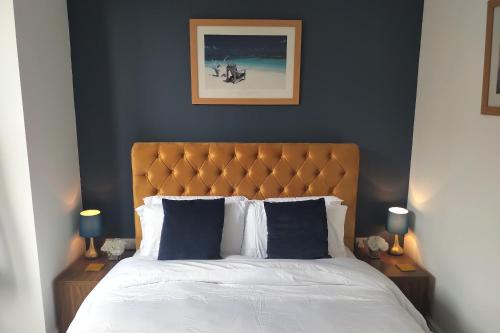 a bedroom with a bed with two nightstands and two lamps at Oliver Wests Beautiful 1 Bedroom Retreat in Scarborough