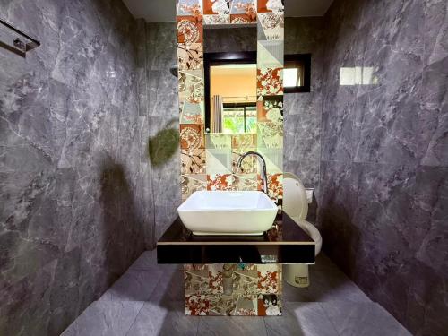 a bathroom with a sink and a mirror at Farinda Resort in Phangnga