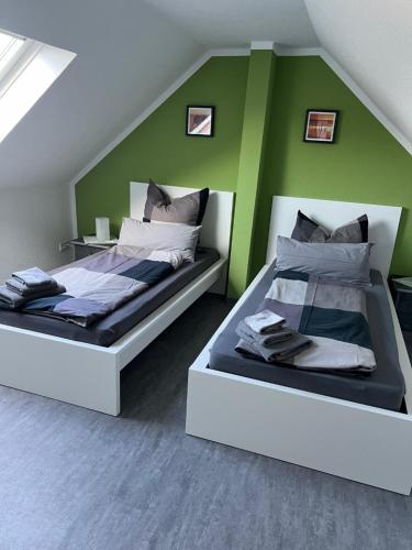 two beds in a room with green walls at Zum Josefstal zwei in Sankt Ingbert