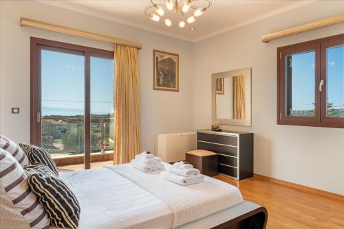 a bedroom with a bed and a large window at Villa Omega Kefalonia in Karavádhos