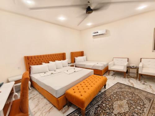 a bedroom with a large bed and a couch at Hotel DE Smart Multan in Multan