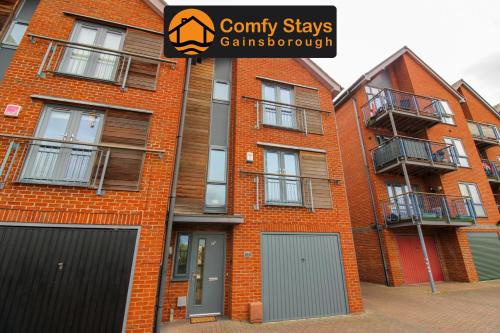 an orange brick building with grey doors and windows at Luxury Riverside Living in Morton
