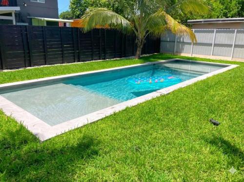 a swimming pool in a yard with a palm tree at Wynwood Bungalows By Renzzi in Miami