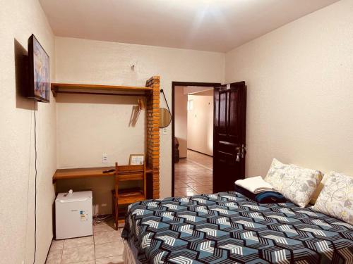 a bedroom with a bed and a desk in it at Rochas - Suíte no Centro de Viçosa do Ceará in Viçosa do Ceará