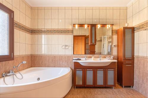 a bathroom with a tub and a sink at Villa Omega Kefalonia in Karavádhos