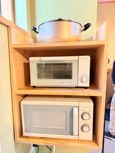 a microwave and a pot sitting on a shelf at 東京雷門ー千の森Asakusa in Tokyo