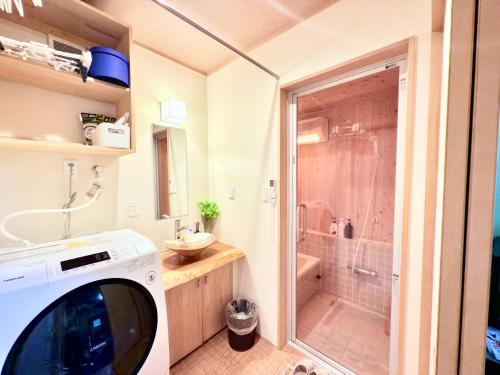 a washing machine in a bathroom with a shower at 東京雷門ー千の森Asakusa in Tokyo