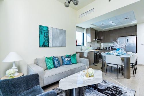 a living room with a couch and a table at Nasma - Modern Apartments with Balcony in Azizi Riviera in Dubai