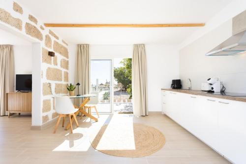 a kitchen with white walls and a table and chairs at Eden Rentals Costa Boho 2 in Las Galletas