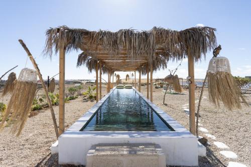 a pool of water under a thatched roof at Eden Rentals Costa Boho 2 in Las Galletas