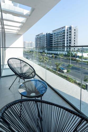 two chairs on a balcony with a view of a city at Nasma - Modern Apartments with Balcony in Azizi Riviera in Dubai
