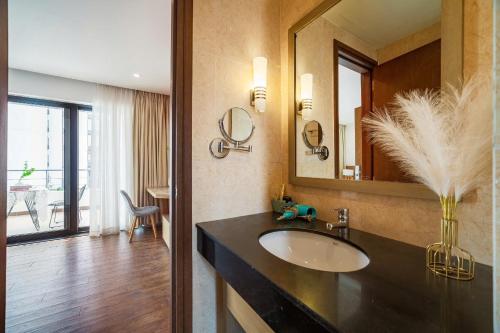 a bathroom with a sink and a large mirror at Căn Hộ Cao Cấp - Villa 5 Phòng Ngủ Hạ Long in Ha Long