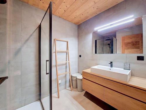 Chalet Superbaz في Seytroux: حمام مزود بحوض ومِرآة وسلّم
