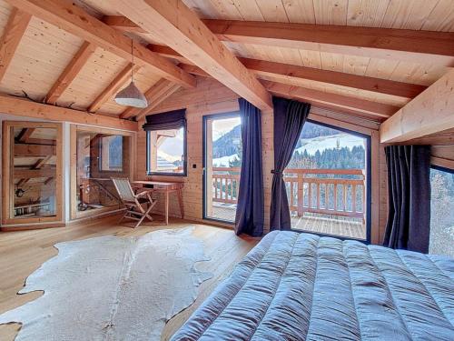 Chalet Superbaz في Seytroux: غرفة نوم بها سرير في غرفة بها نوافذ