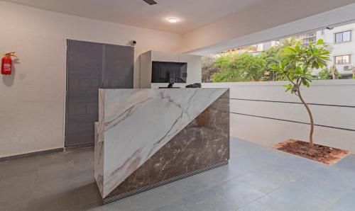 a large marble counter in a room with a plant at Treebo Atithi Comforts Inn in Pune