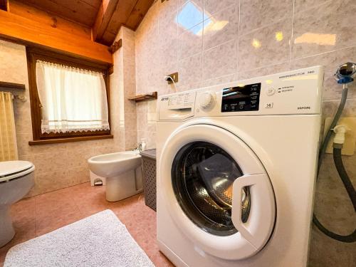 a washing machine in a bathroom with a toilet at Casa Flora -lakefront and Tre Cime view in Auronzo di Cadore