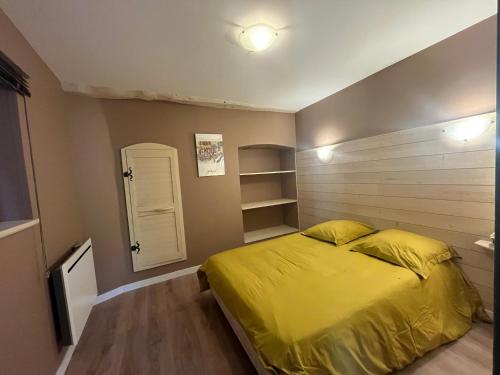 a bedroom with a bed with a yellow comforter at Apartment in Mostuejouls in Mostuéjouls