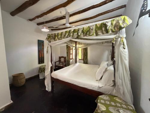 a bedroom with a canopy bed in a room at Nyumba Malaika in Malindi