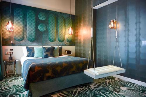 a bedroom with a bed and a wall with a painting at Paris j'Adore Hotel & Spa in Paris