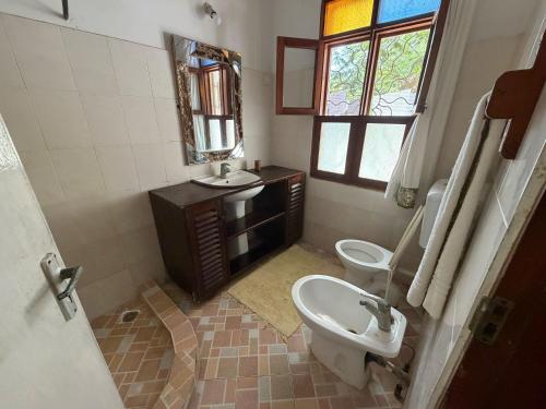 a bathroom with a sink and a toilet and a mirror at Nyumba Malaika in Malindi
