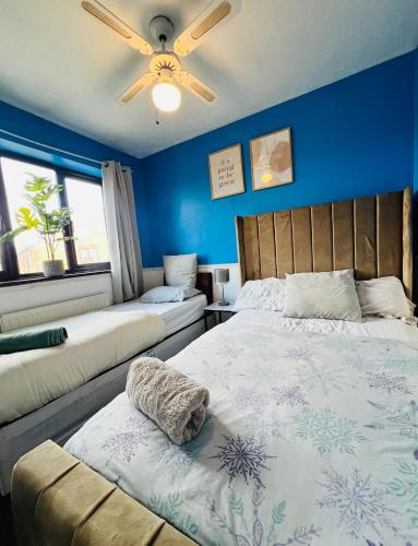a bedroom with two beds and a ceiling fan at Olive, 3Bedrooms,1 extra Rm, Sleeps 9 with Garden, Free Parking in Grays, Lakeside, London in Grays Thurrock
