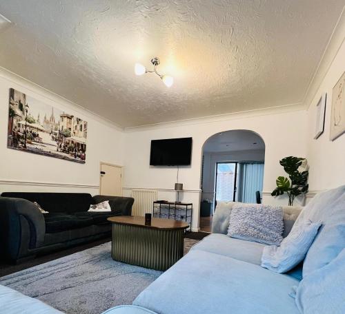 a living room with a couch and a table at Olive, 3Bedrooms,1 extra Rm, Sleeps 9 with Garden, Free Parking in Grays, Lakeside, London in Grays Thurrock