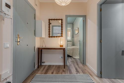 a hallway with a table and a mirror and a bed at Comfortable and spacious flat in Barcelona in Barcelona