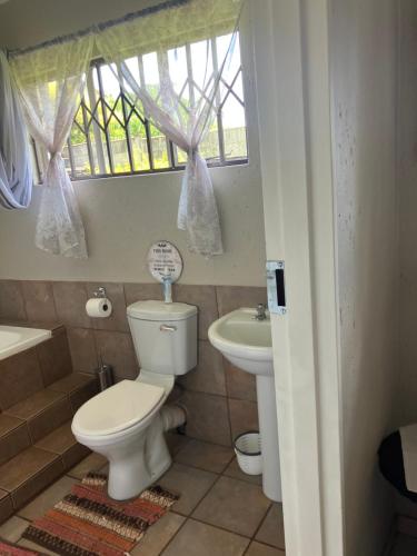 a bathroom with a toilet and a sink at Cave view Cottages in Muldersdrift