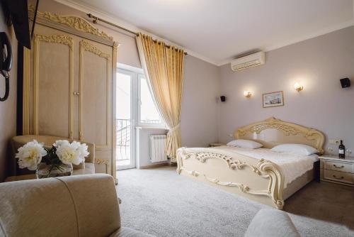 ein Schlafzimmer mit einem weißen Bett und einem großen Fenster in der Unterkunft Ekaterina II Hotel in Odessa