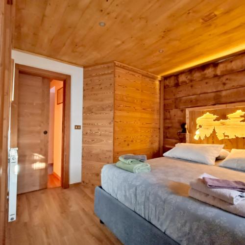 a bedroom with two beds in a wooden room at Maso Clementina in Pieve Tesino