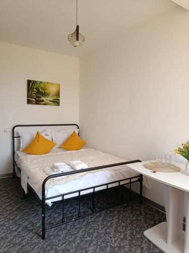 a bed with two yellow pillows and a sink in a room at Studio M in Timişoara