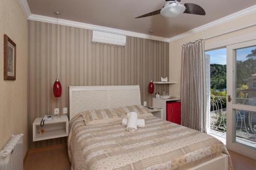 a bedroom with a large bed and a balcony at Doce Canela - Pousada de Charme in Canela