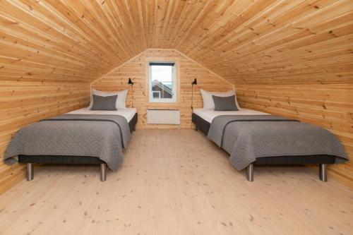 two beds in a room with a wooden ceiling at Kongsberg Booking in Kongsberg