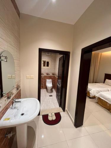 a bathroom with a sink and a toilet and a bed at شقق ضيافه خاصه 5391 in Yanbu