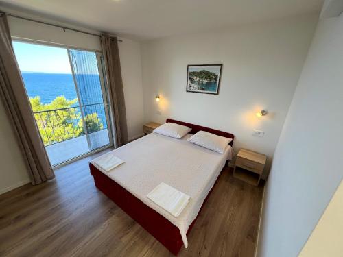 a bedroom with a bed and a large window at Robinson Olympos in Gdinj