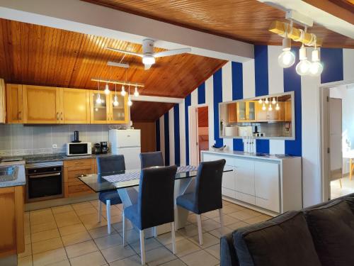 a kitchen with a table and chairs in a room at Cantinho a Sul - Costa Nova in Gafanha da Encarnação