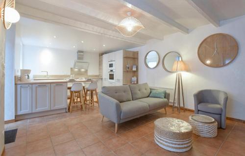 a living room with a couch and a kitchen at Maison Proche Port Et Plage in Saint-Vaast-la-Hougue